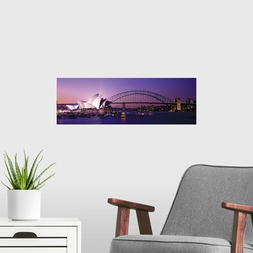 A modern room featuring Panoramic photograph of floating music house with city skyline and bridge in the distance at sunset.
