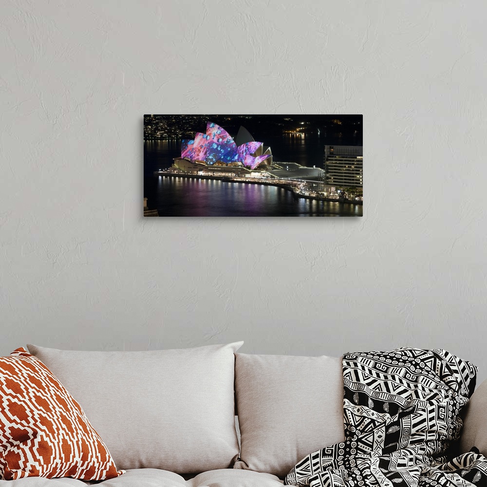 A bohemian room featuring This landscape photograph shows colorful lights and illustrations projected on to this landmark b...