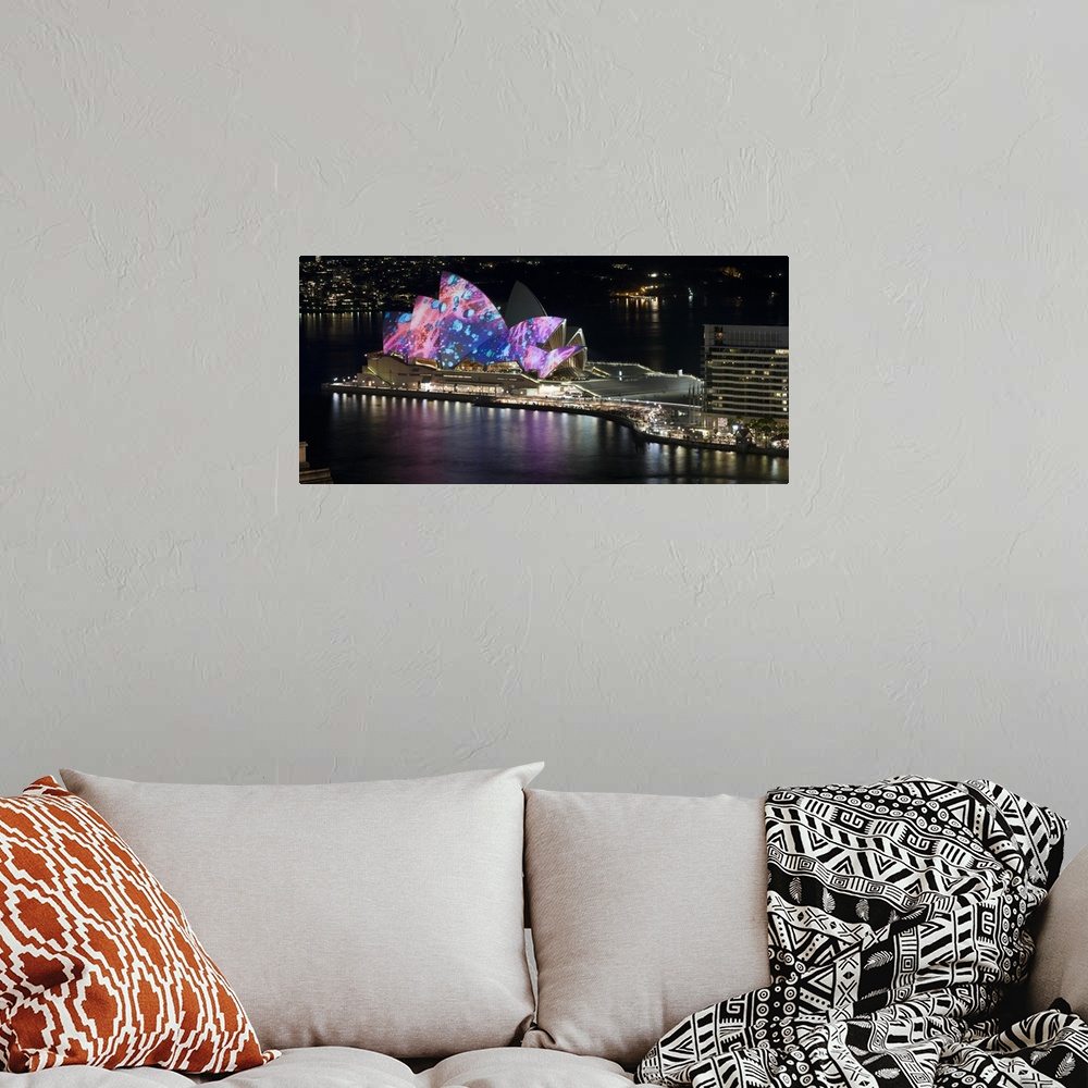 A bohemian room featuring This landscape photograph shows colorful lights and illustrations projected on to this landmark b...