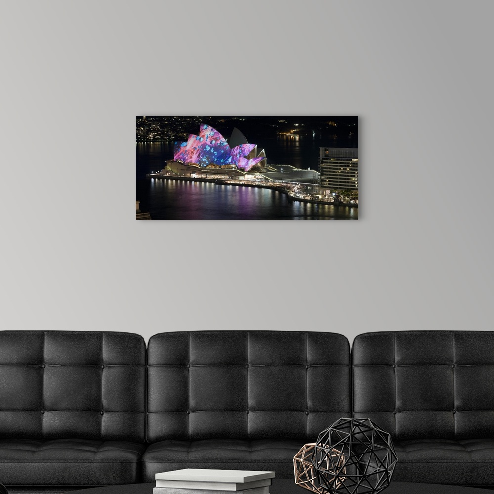 A modern room featuring This landscape photograph shows colorful lights and illustrations projected on to this landmark b...