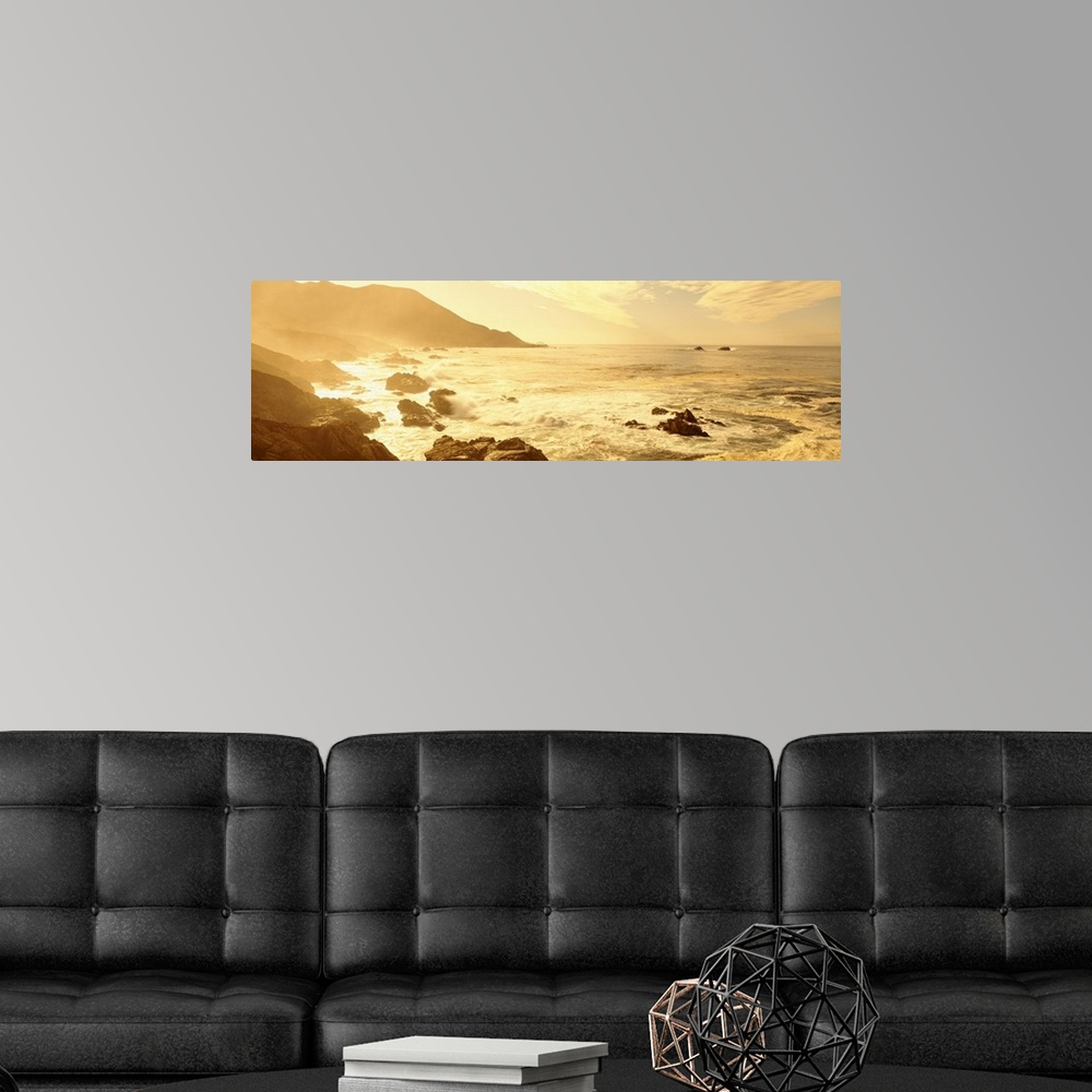 A modern room featuring Wide angle photograph on a big canvas of the Pacific Ocean along a rocky coast line in California...