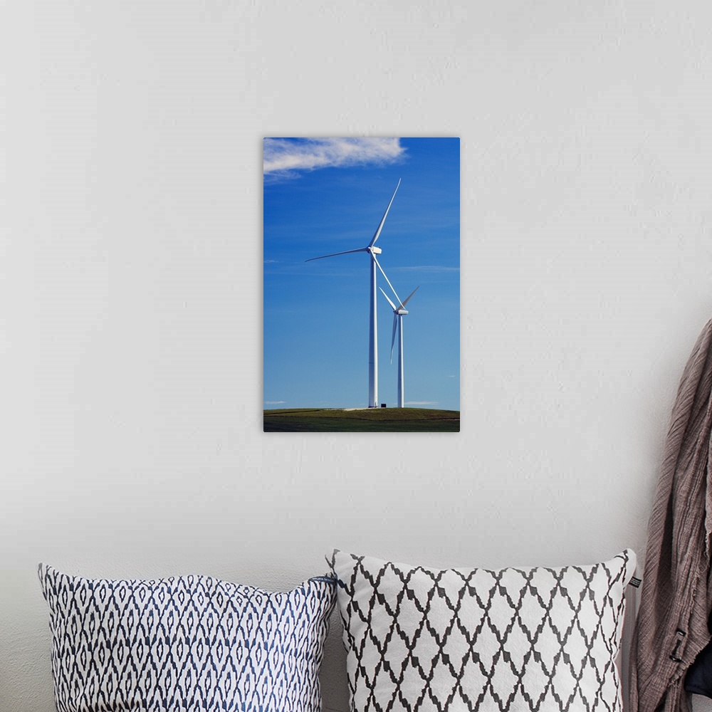 A bohemian room featuring Pair of wind farm turbines in green grass, blue sky, Montana