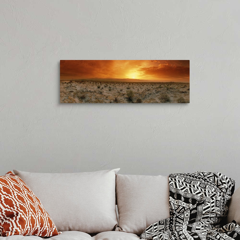 A bohemian room featuring Big, horizontal photograph of a fiery sunset over the desert in Palm Springs, California.