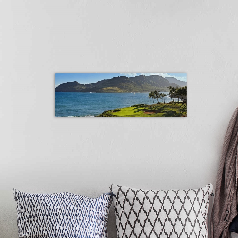 A bohemian room featuring Panoramic photograph taken from a golf course of a large mountain across a lagoon in Hawaii.