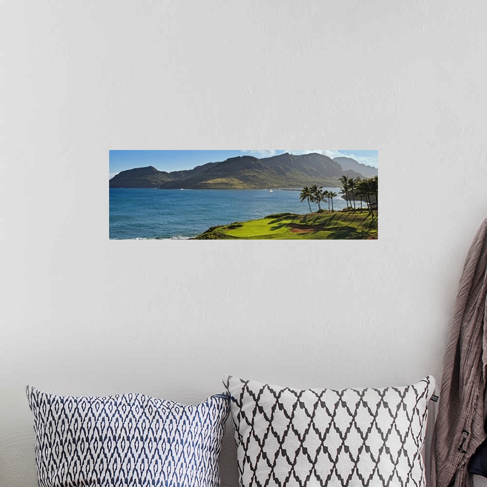 A bohemian room featuring Panoramic photograph taken from a golf course of a large mountain across a lagoon in Hawaii.
