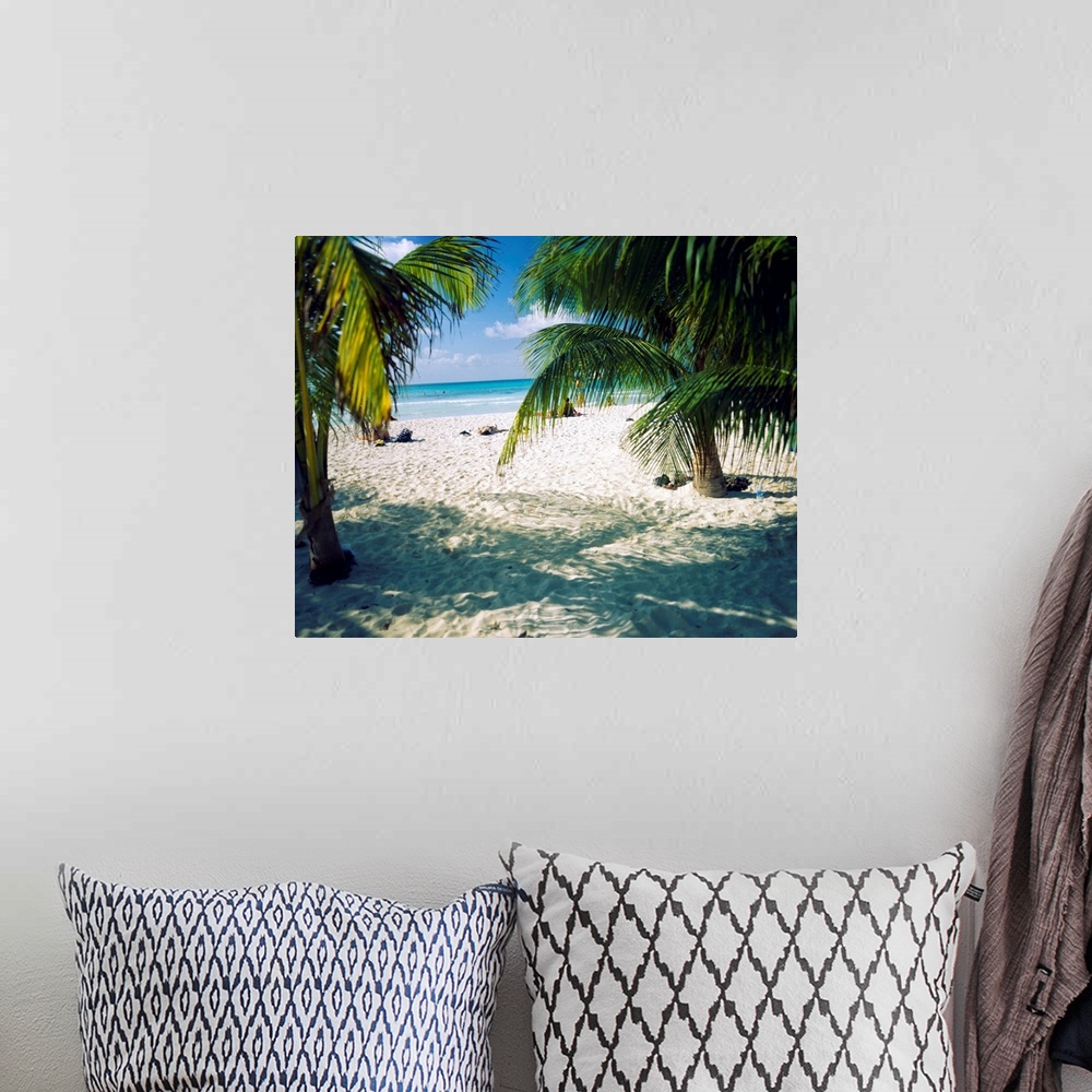A bohemian room featuring Huge photograph displays the view of a sandy beach and ocean through the fronds of a few tropical...