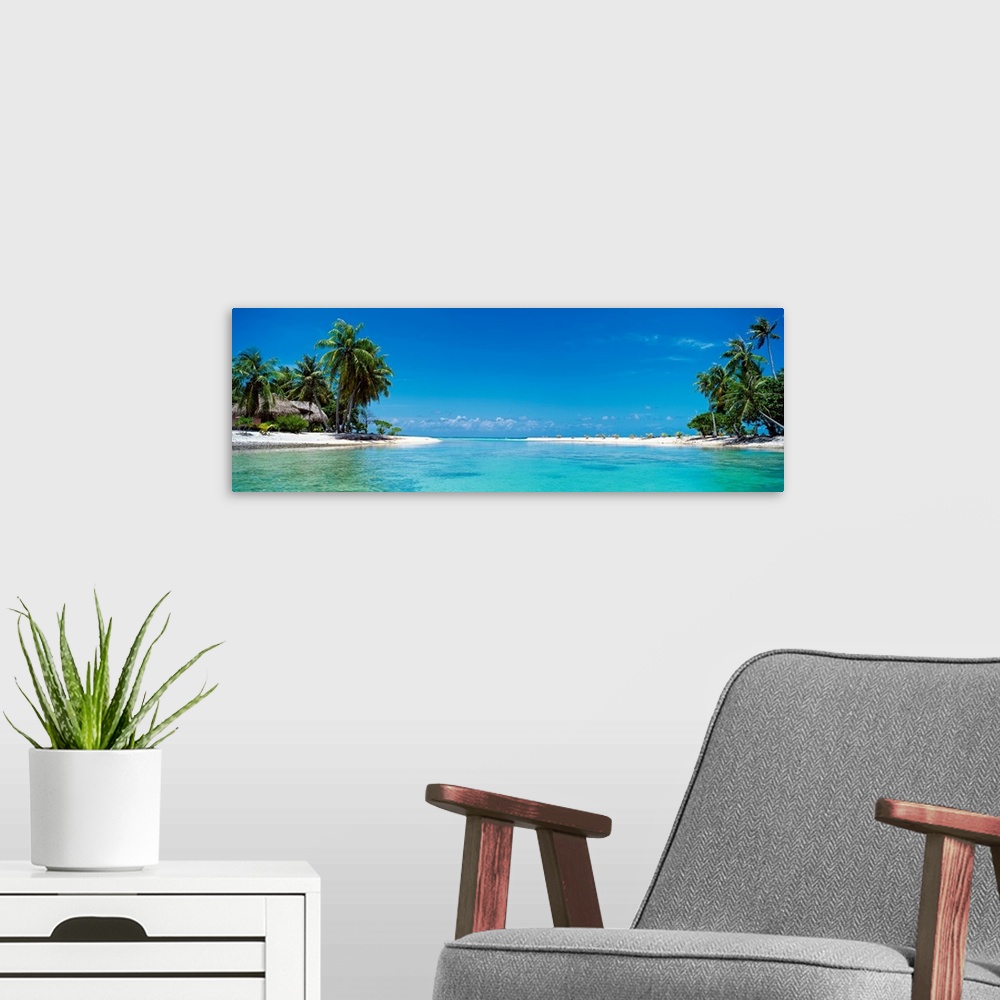 A modern room featuring A panoramic photograph of a tropical lagoon surrounded by trees and huts.