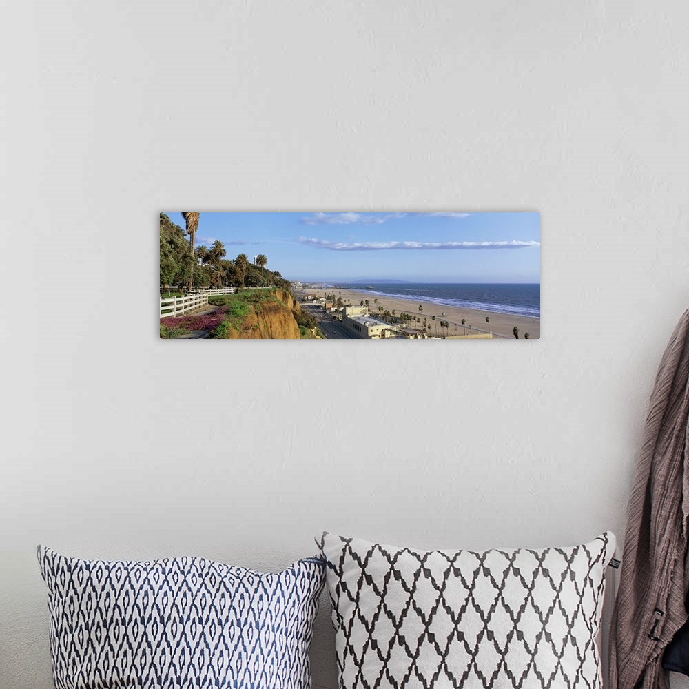 A bohemian room featuring Panoramic photograph of cliff overlooking shoreline filled with buildings and palm trees under a ...