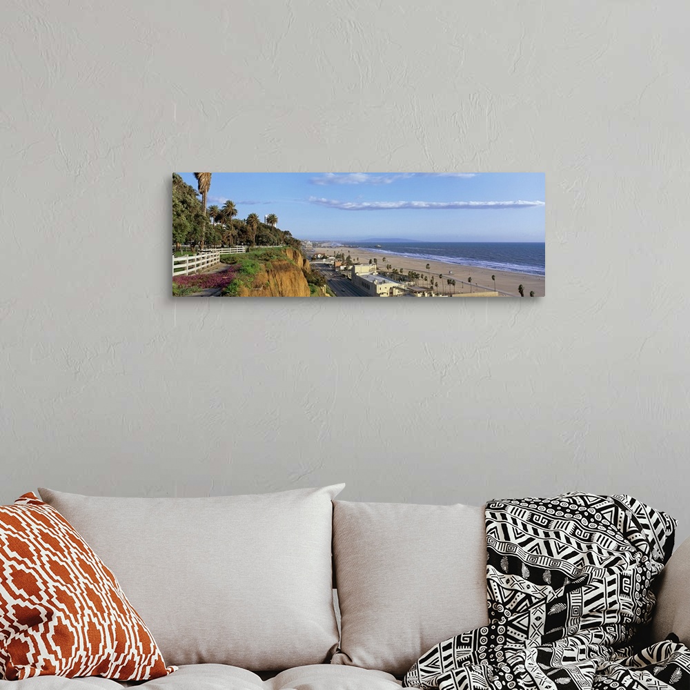 A bohemian room featuring Panoramic photograph of cliff overlooking shoreline filled with buildings and palm trees under a ...
