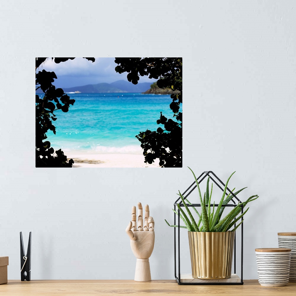 A bohemian room featuring Large photograph shows the clear water of a beach in Cinnamon Bay through a silhouetted outline o...