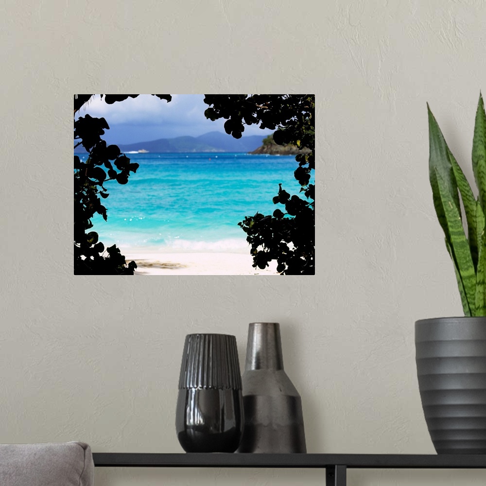 A modern room featuring Large photograph shows the clear water of a beach in Cinnamon Bay through a silhouetted outline o...