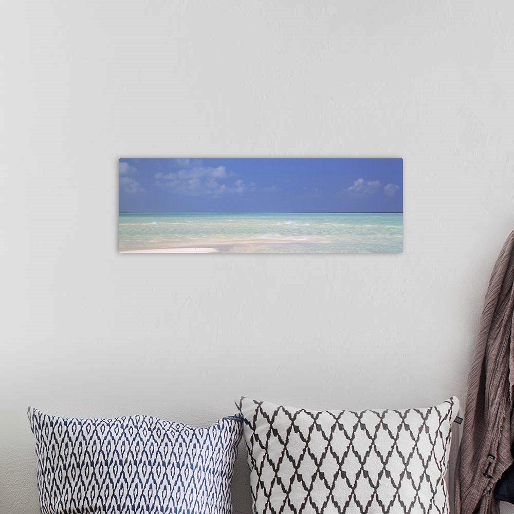 A bohemian room featuring Panoramic canvas photo of a clear ocean meeting a sandy beach.