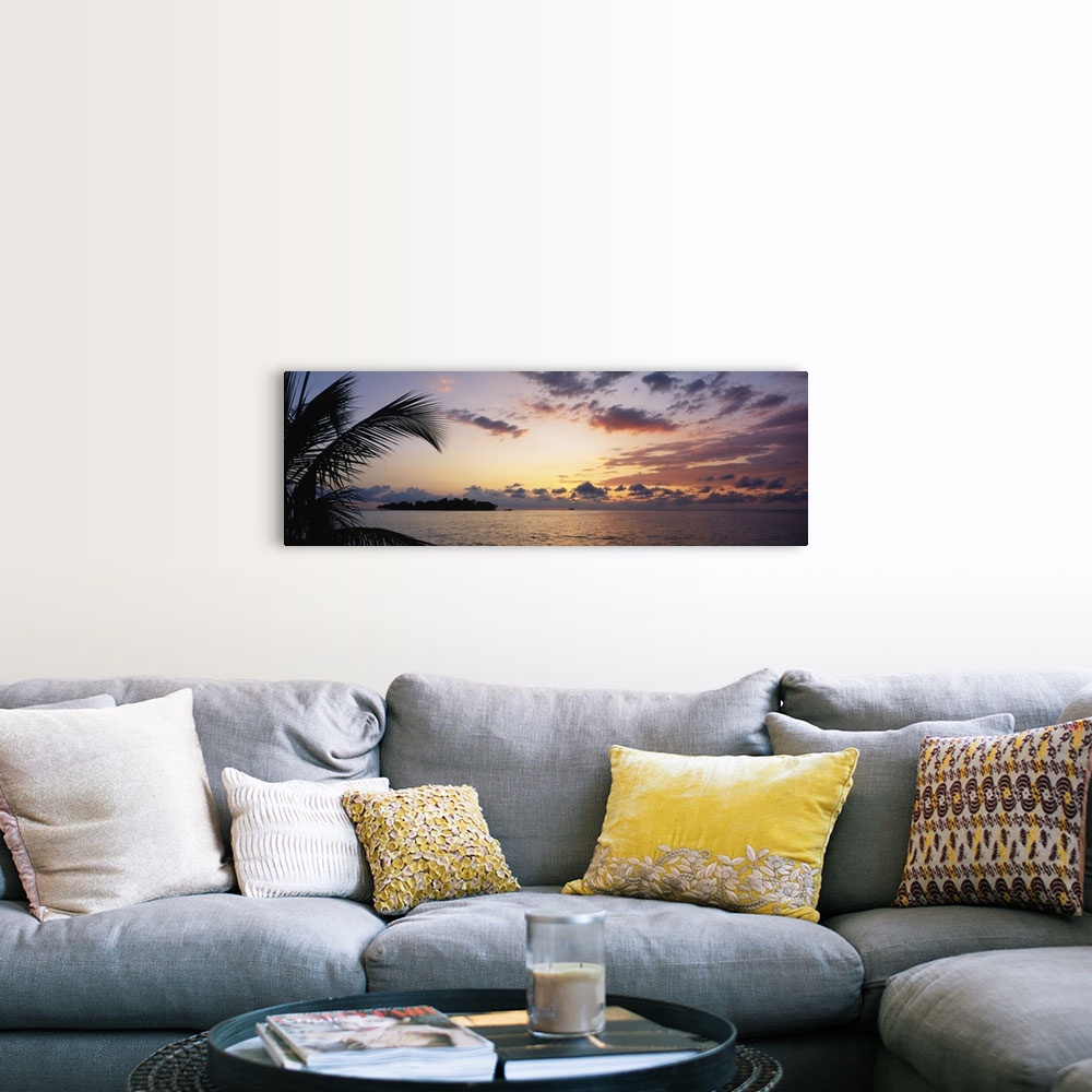 A farmhouse room featuring Wide angle photograph of a cloudy ocean sunset with the silhouette of a palm tree in the foregrou...