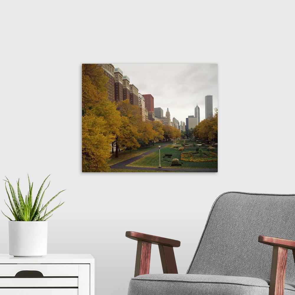 A modern room featuring A Chicago park in autumn is photographed with buildings just to the left and behind it in the dis...