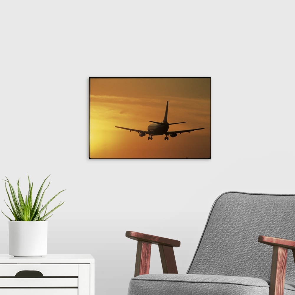 A modern room featuring Photo print of a jumbo jet flying into a sunset after take off.
