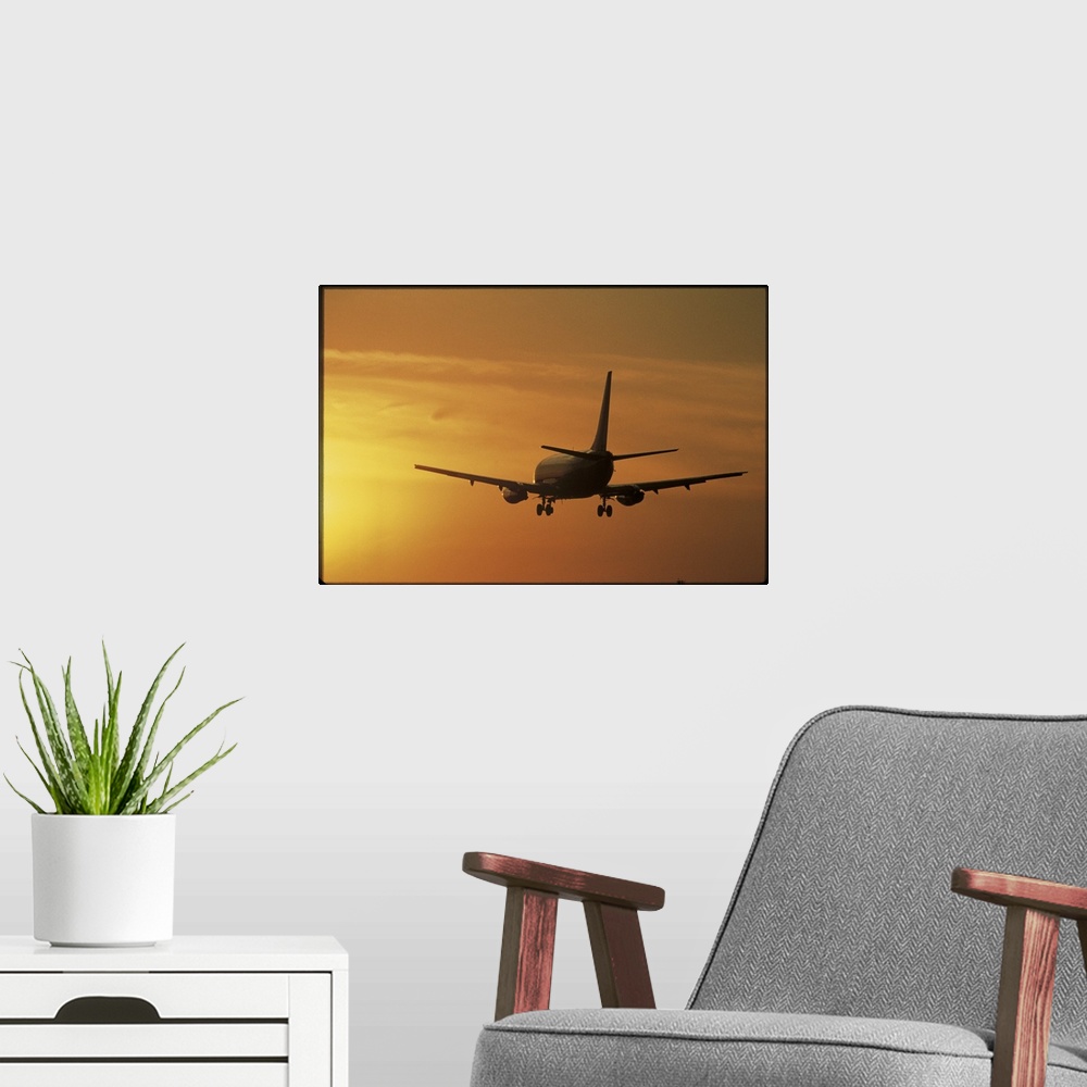 A modern room featuring Photo print of a jumbo jet flying into a sunset after take off.