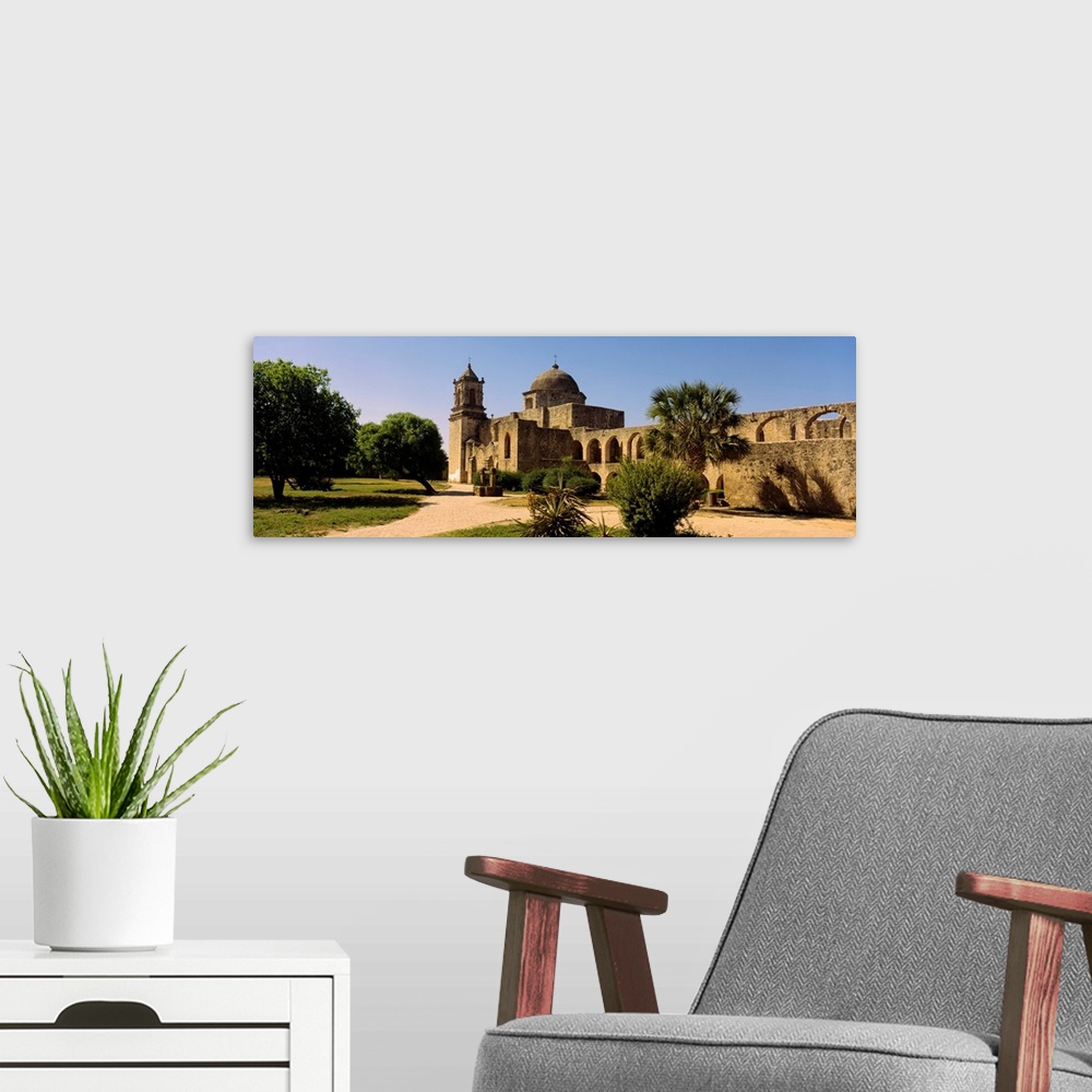 A modern room featuring Panoramic photograph of a brick path leading toward the historic Mission San Jose, surrounding by...