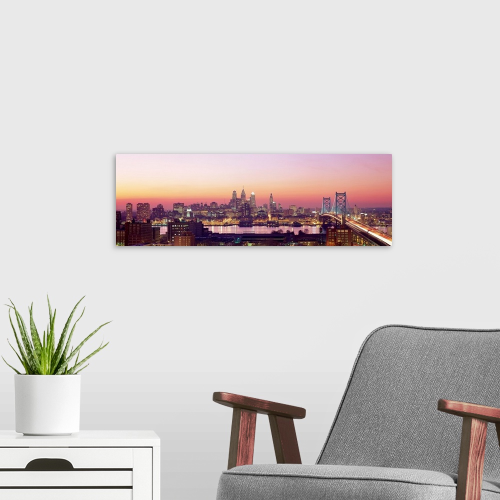 A modern room featuring Panoramic photograph displays the busy skyline and Benjamin Franklin bridge in Philadelphia, Penn...
