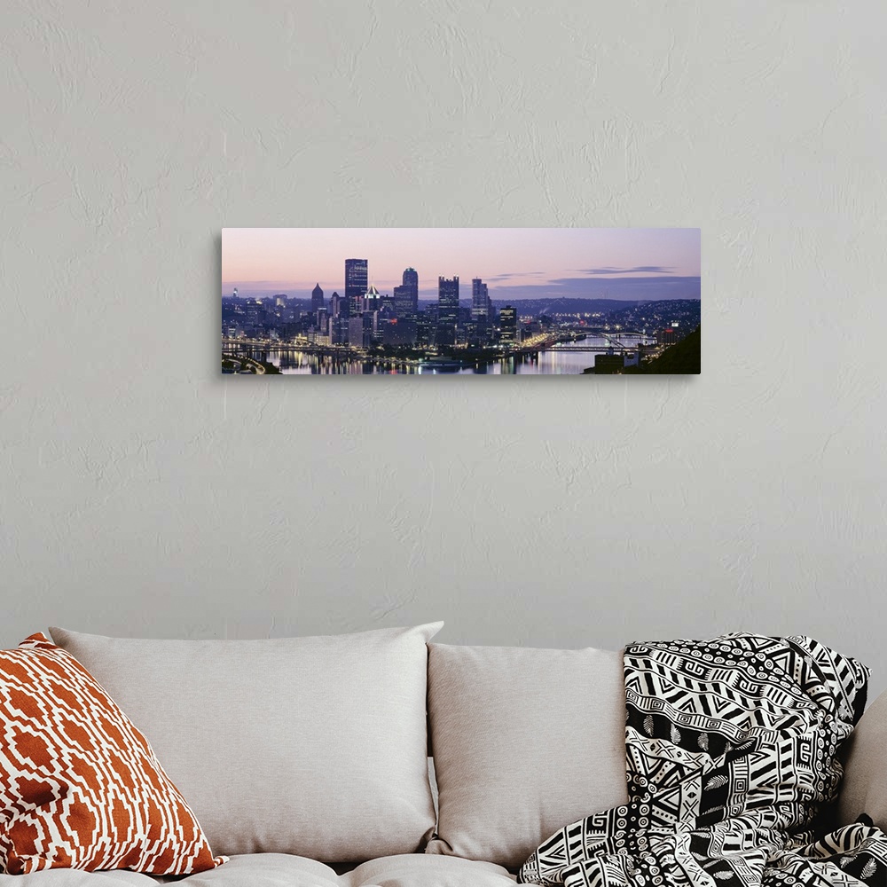 A bohemian room featuring Panoramic photograph of skyline and waterfront lit up at sunset.