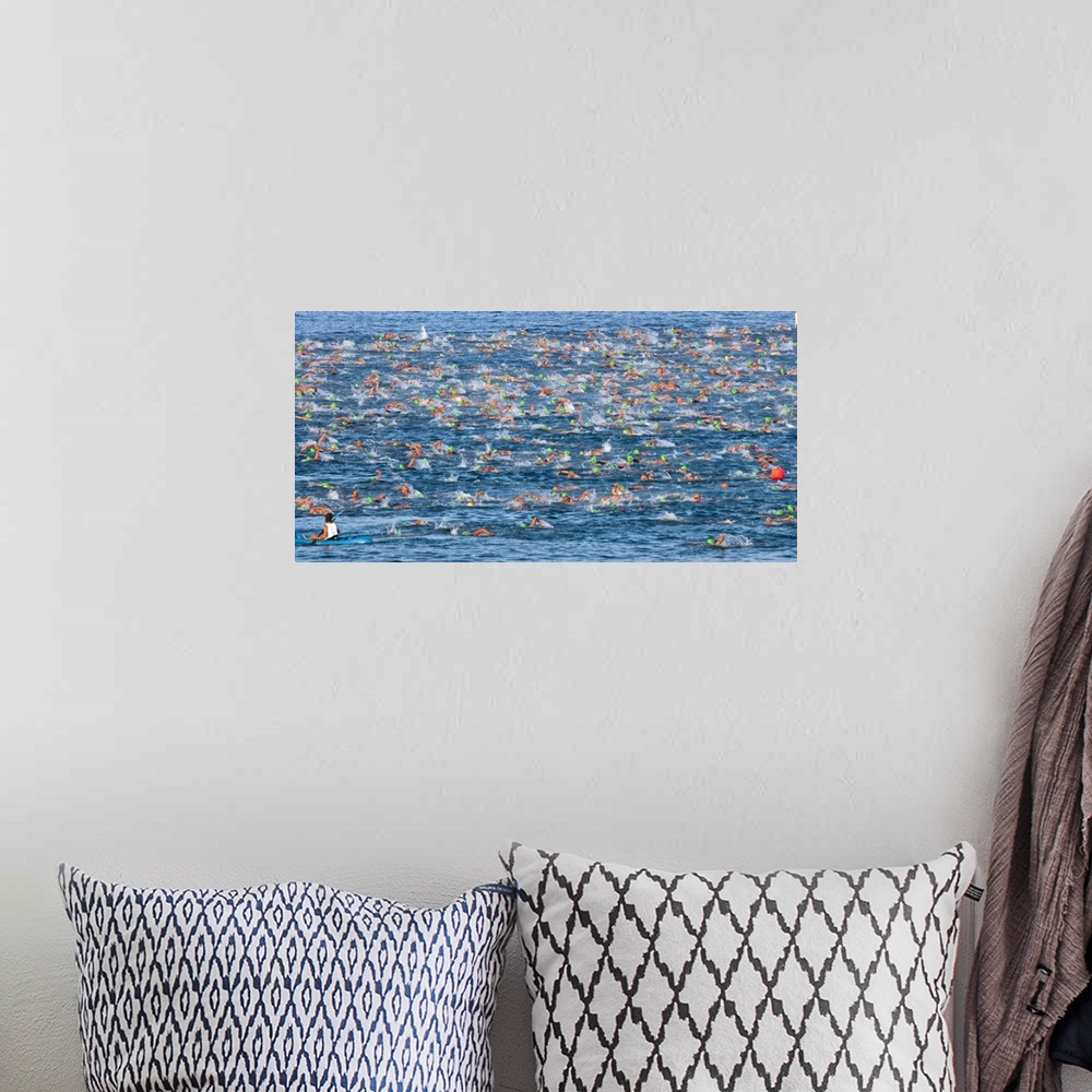 A bohemian room featuring Horizontal photo on canvas of triathletes swimming in the ocean during the Ironman Kona race.