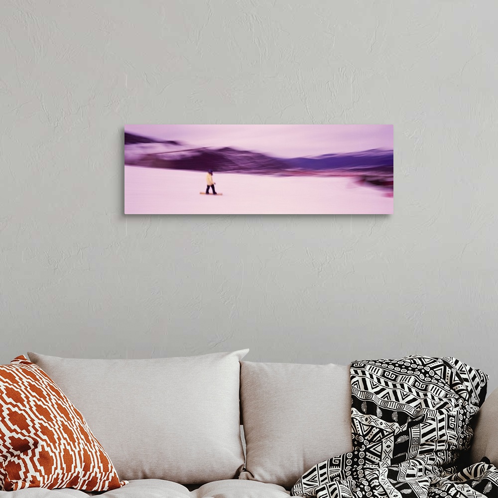 A bohemian room featuring Panoramic photo of someone snowboarding down a mountain printed on canvas.