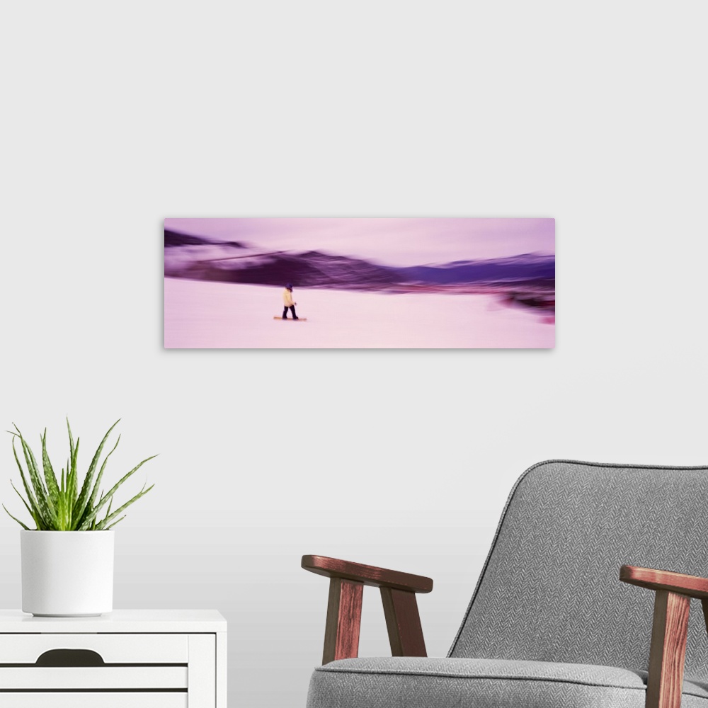 A modern room featuring Panoramic photo of someone snowboarding down a mountain printed on canvas.