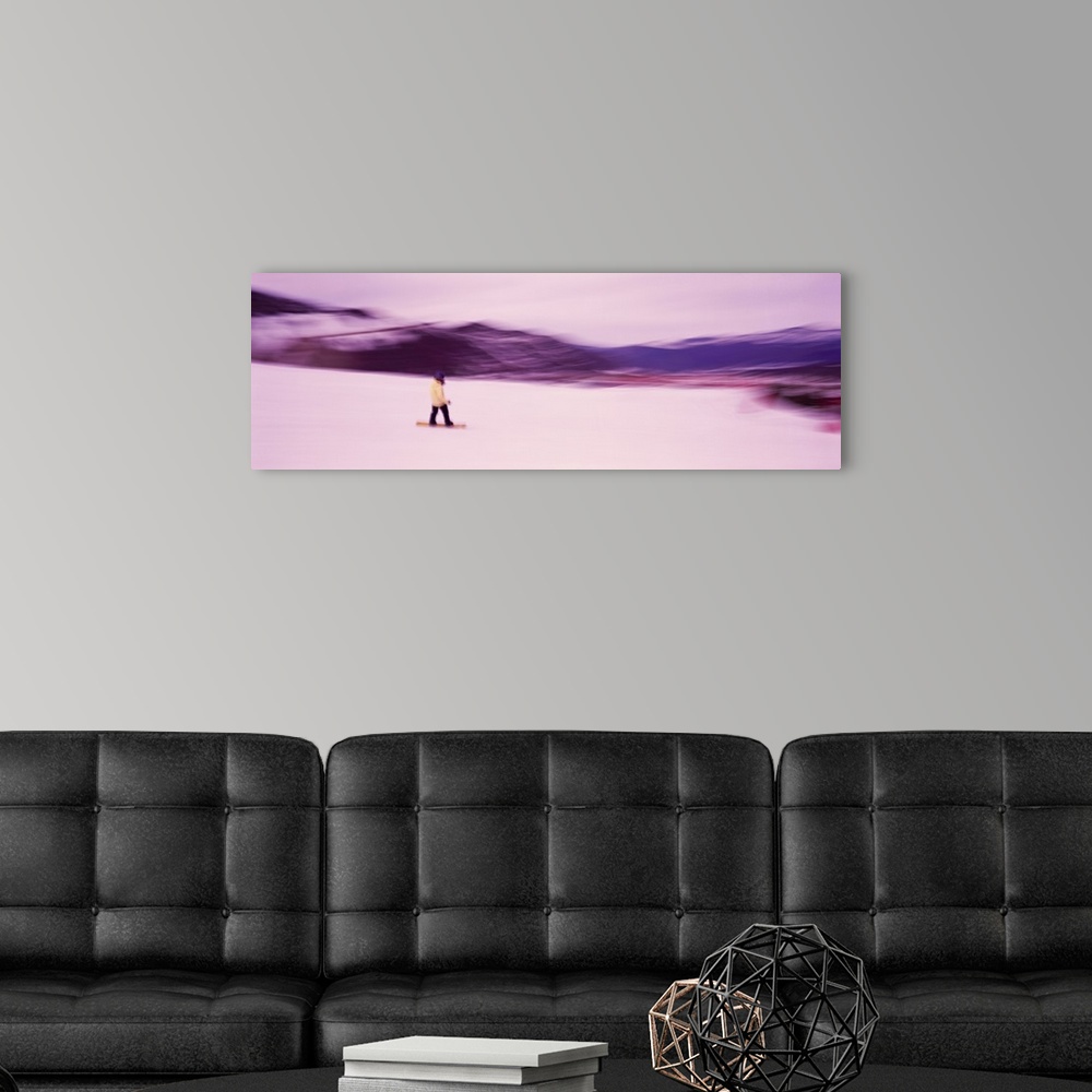 A modern room featuring Panoramic photo of someone snowboarding down a mountain printed on canvas.