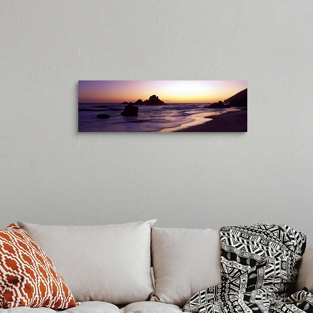 A bohemian room featuring Sunset panoramic of the rocky beach in California.