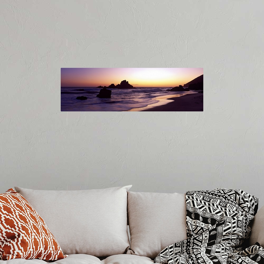 A bohemian room featuring Sunset panoramic of the rocky beach in California.