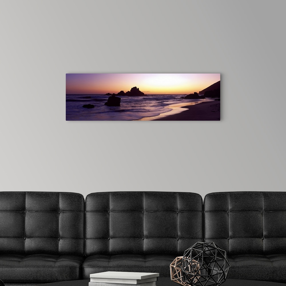A modern room featuring Sunset panoramic of the rocky beach in California.