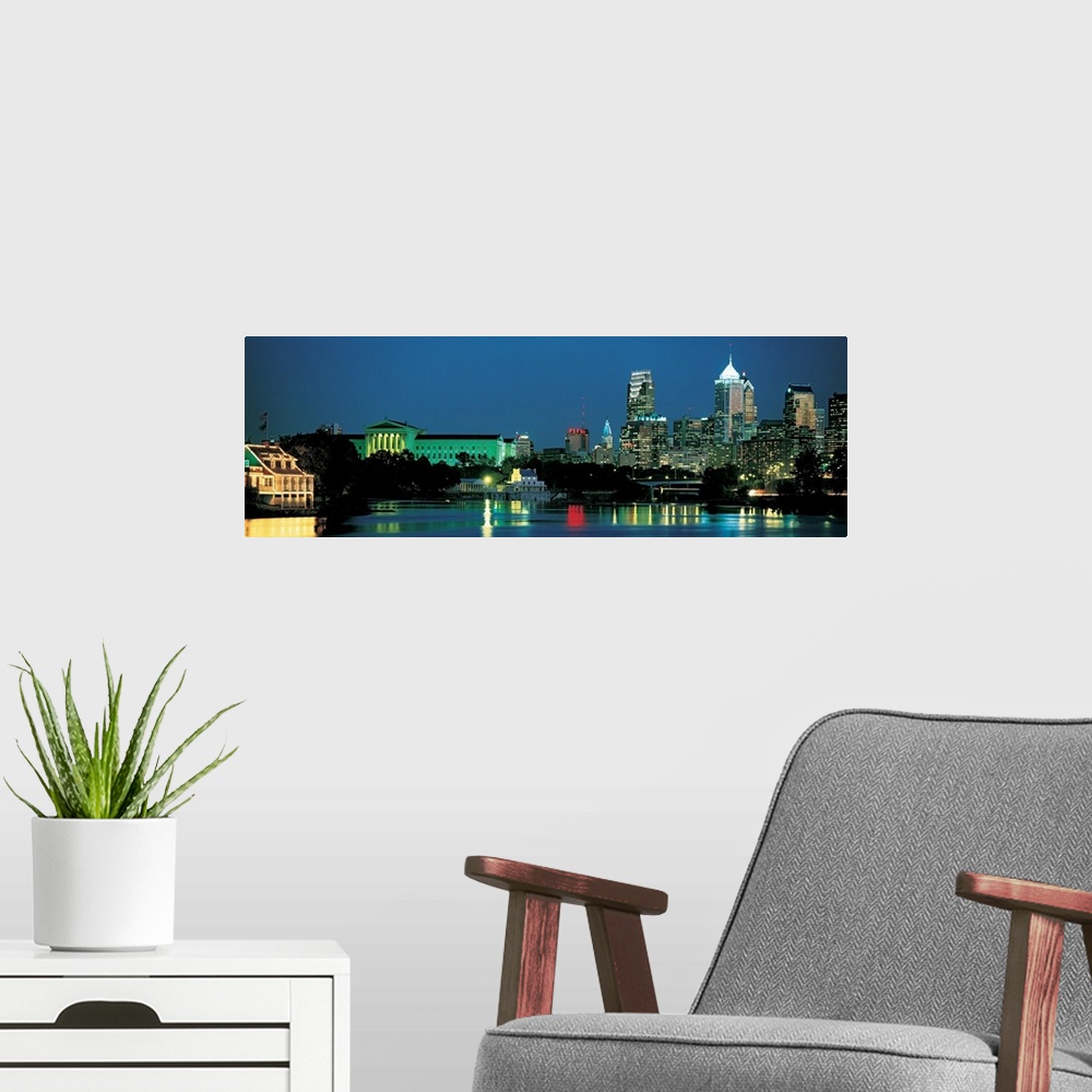 A modern room featuring Panoramic photograph of the Philadelphia, Pennsylvania skyline taken at night.  The bright lights...