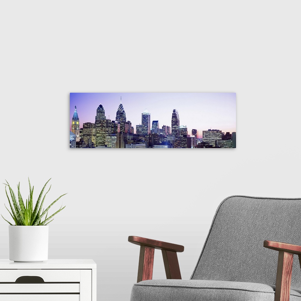 A modern room featuring Philly citiscape at dusk with buildings lit up.