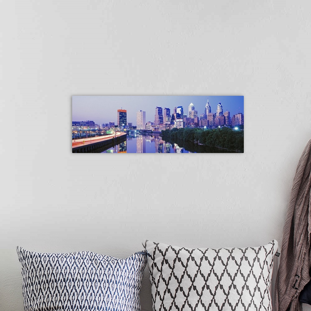 A bohemian room featuring This artwork is a panoramic canvas of the city skyline reflecting in the river water at dusk.
