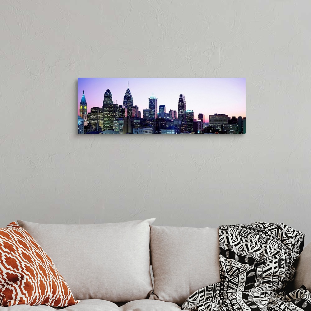 A bohemian room featuring A panoramic photograph of the downtown city skylineos skyscrapers at dusk.