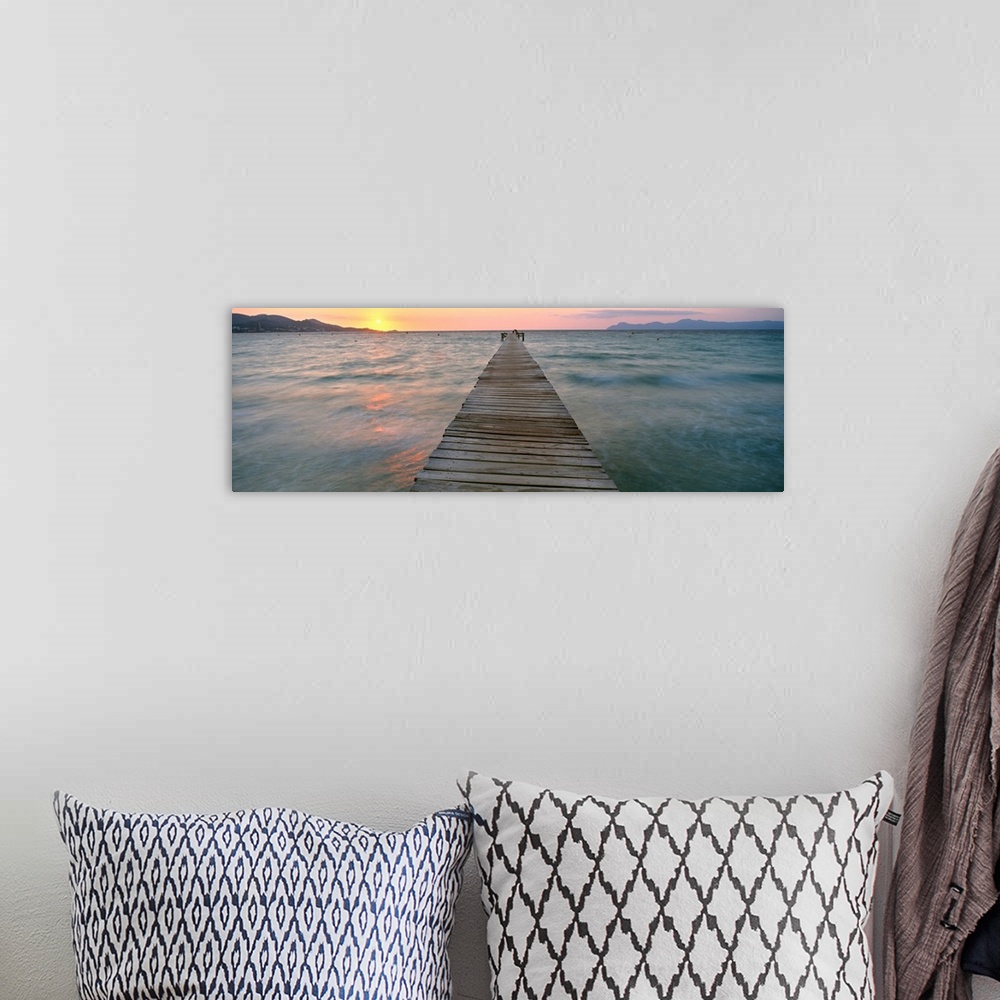 A bohemian room featuring Panoramic photograph of wooden dock stretching into ocean at dusk with mountain silhouettes in th...