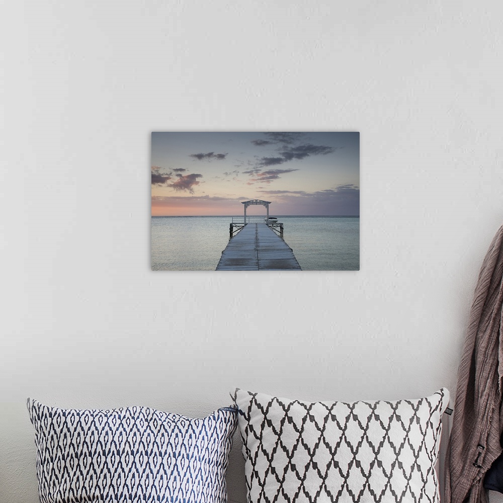 A bohemian room featuring Photograph of wooden dock stretching into ocean at sunset under a cloudy sky.