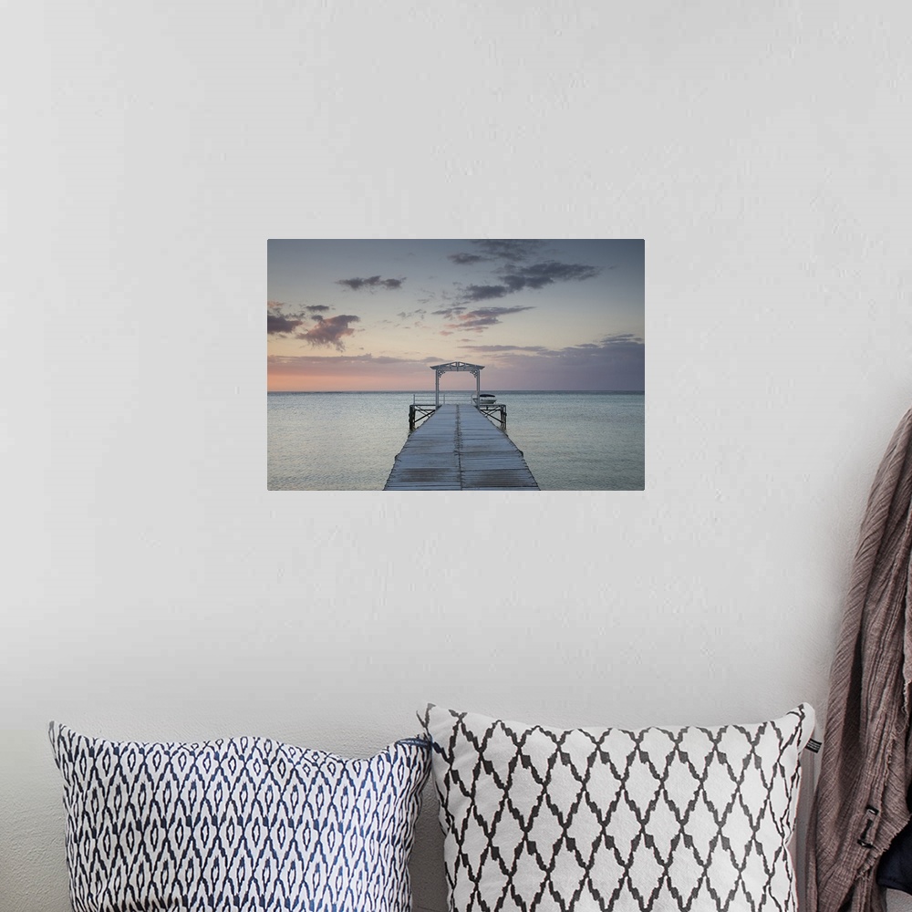 A bohemian room featuring Photograph of wooden dock stretching into ocean at sunset under a cloudy sky.