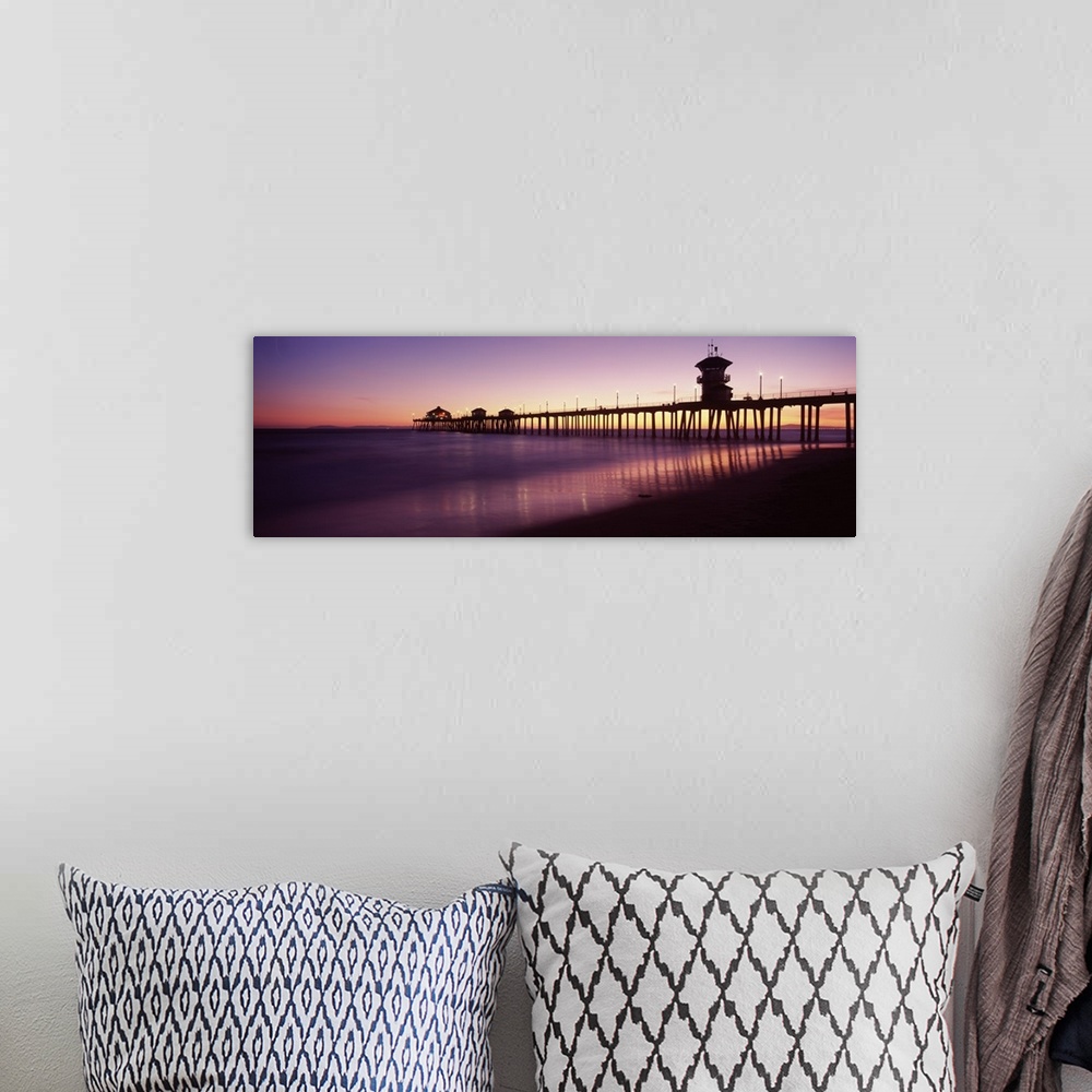 A bohemian room featuring Panoramic photograph composed of a large dock extending into the Pacific Ocean while the waves sl...