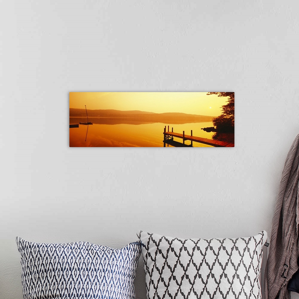 A bohemian room featuring A dock and boat reflect on these still waters at sunrise in this panoramic photograph wall art.