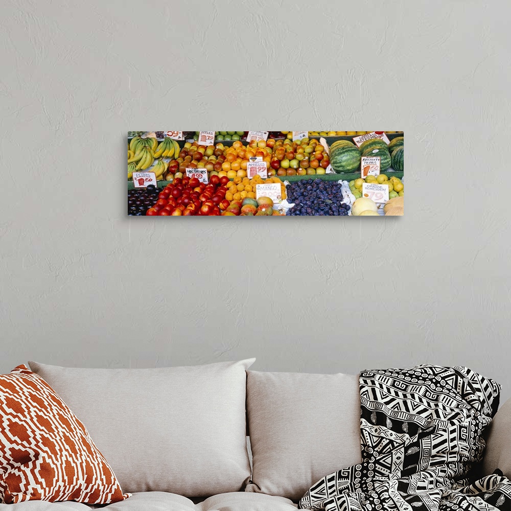 A bohemian room featuring Large, horizontal photograph of a fruit stand with many types of fruit and pricing signage in eac...