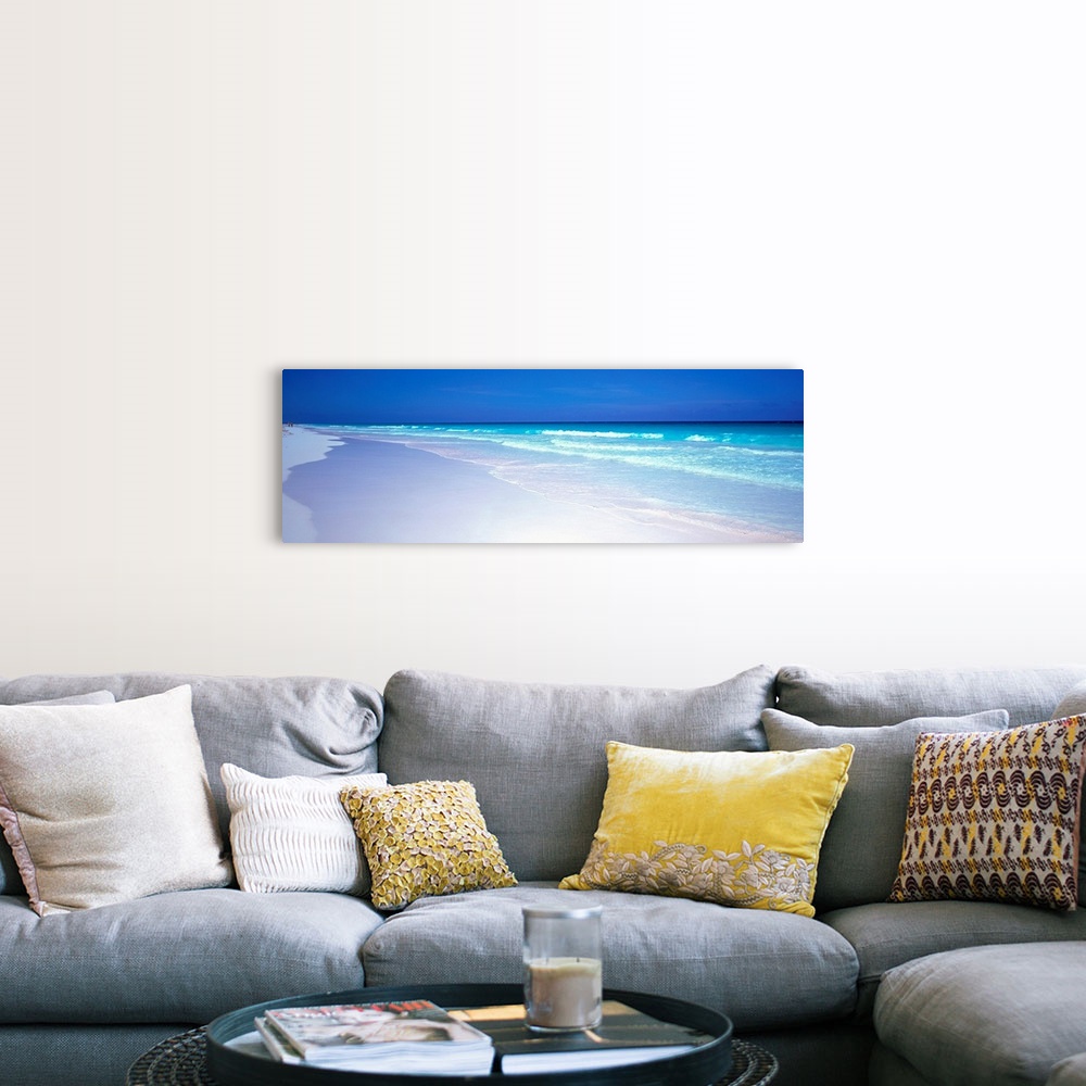 A farmhouse room featuring A panoramic wall art picture of a tropical beach with flawless sand and a clear horizon as waves ...