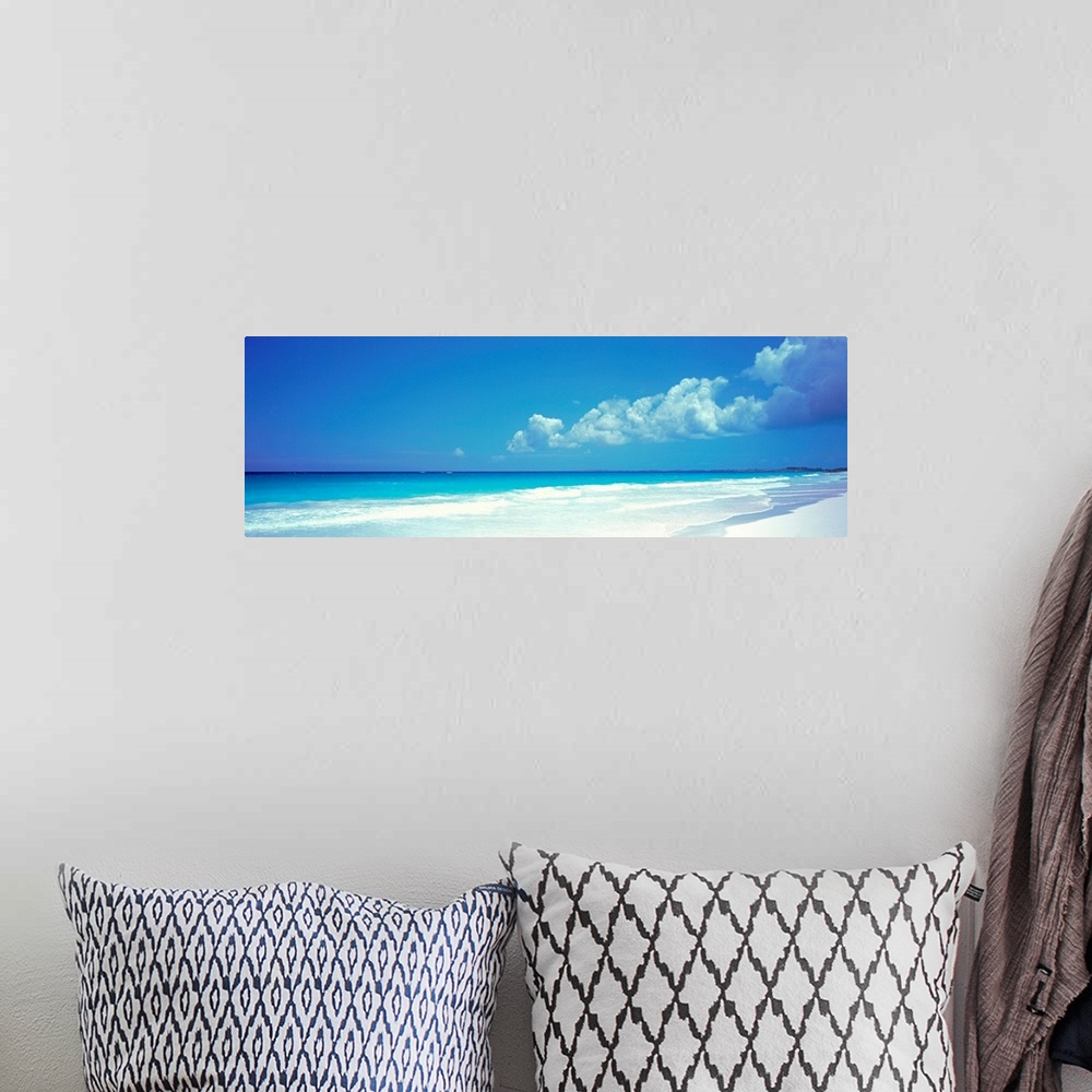 A bohemian room featuring Panoramic photograph includes a near cloudless sky overlooking a sandy beach as the waves from th...