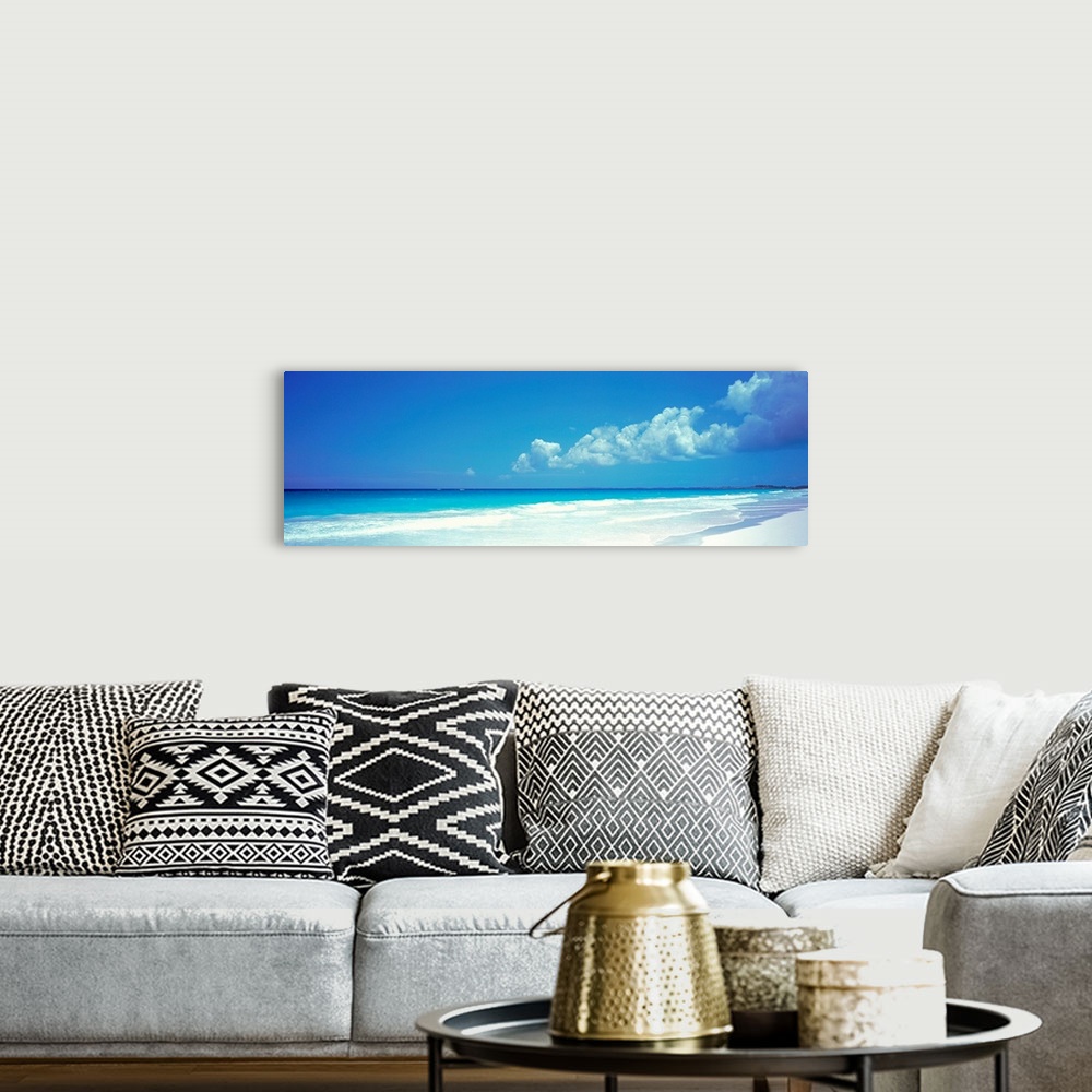 A bohemian room featuring Panoramic photograph includes a near cloudless sky overlooking a sandy beach as the waves from th...