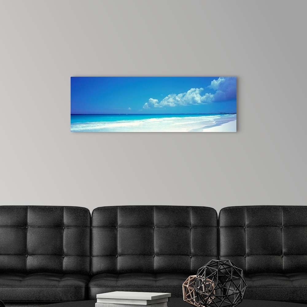 A modern room featuring Panoramic photograph includes a near cloudless sky overlooking a sandy beach as the waves from th...