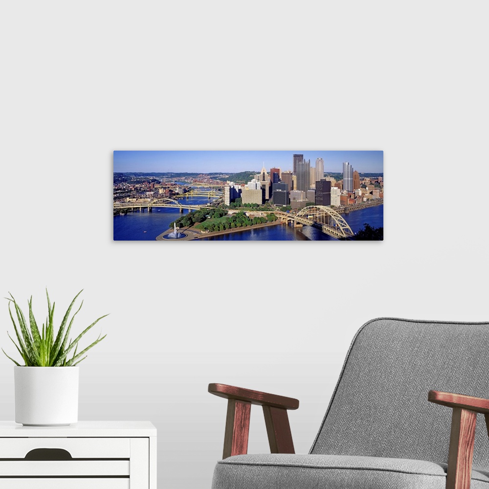 A modern room featuring Panoramic photograph of the skyline, bridges, and Point State Park where the three rivers meet.