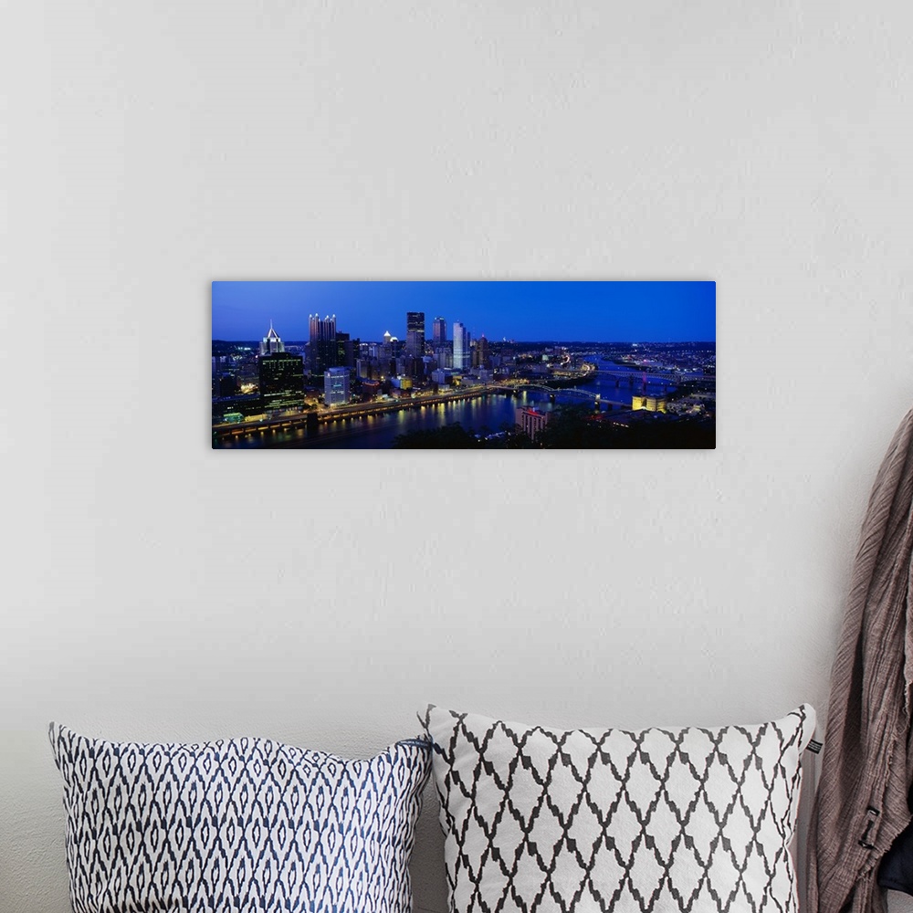 A bohemian room featuring This huge panoramic photograph is of the Pittsburg skyline at night with the buildings lit up and...