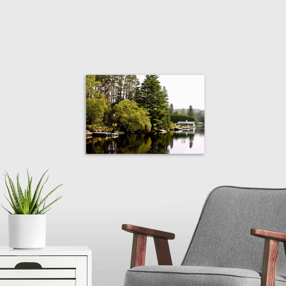 A modern room featuring Placid river with docks, boats and boathouse, Muskoka, Ontario, Canada