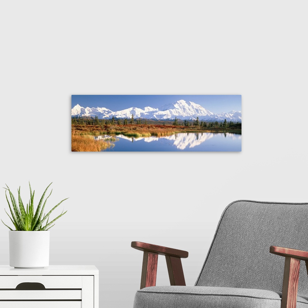 A modern room featuring Panoramic photograph shows a range of snow covered mountains filling the horizon and sitting behi...