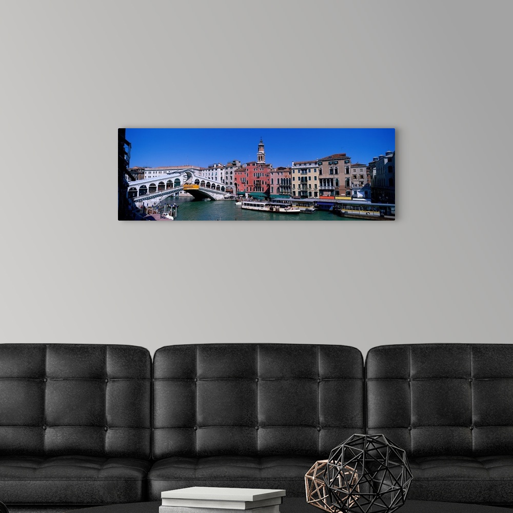 A modern room featuring This panoramic view shows the Rialto bridge over the grand canal in Venice with buildings lining ...