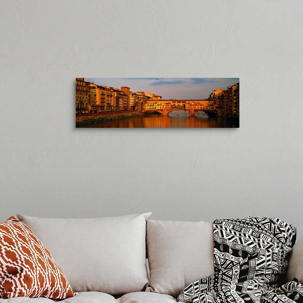 A bohemian room featuring Wide angle photograph of buildings alongside the Arno River, with a view of he Ponte Vecchio brid...